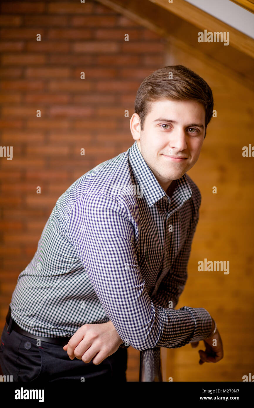 Smiling Young Man Leaning Against Brick Wall Stock Photo - Alamy