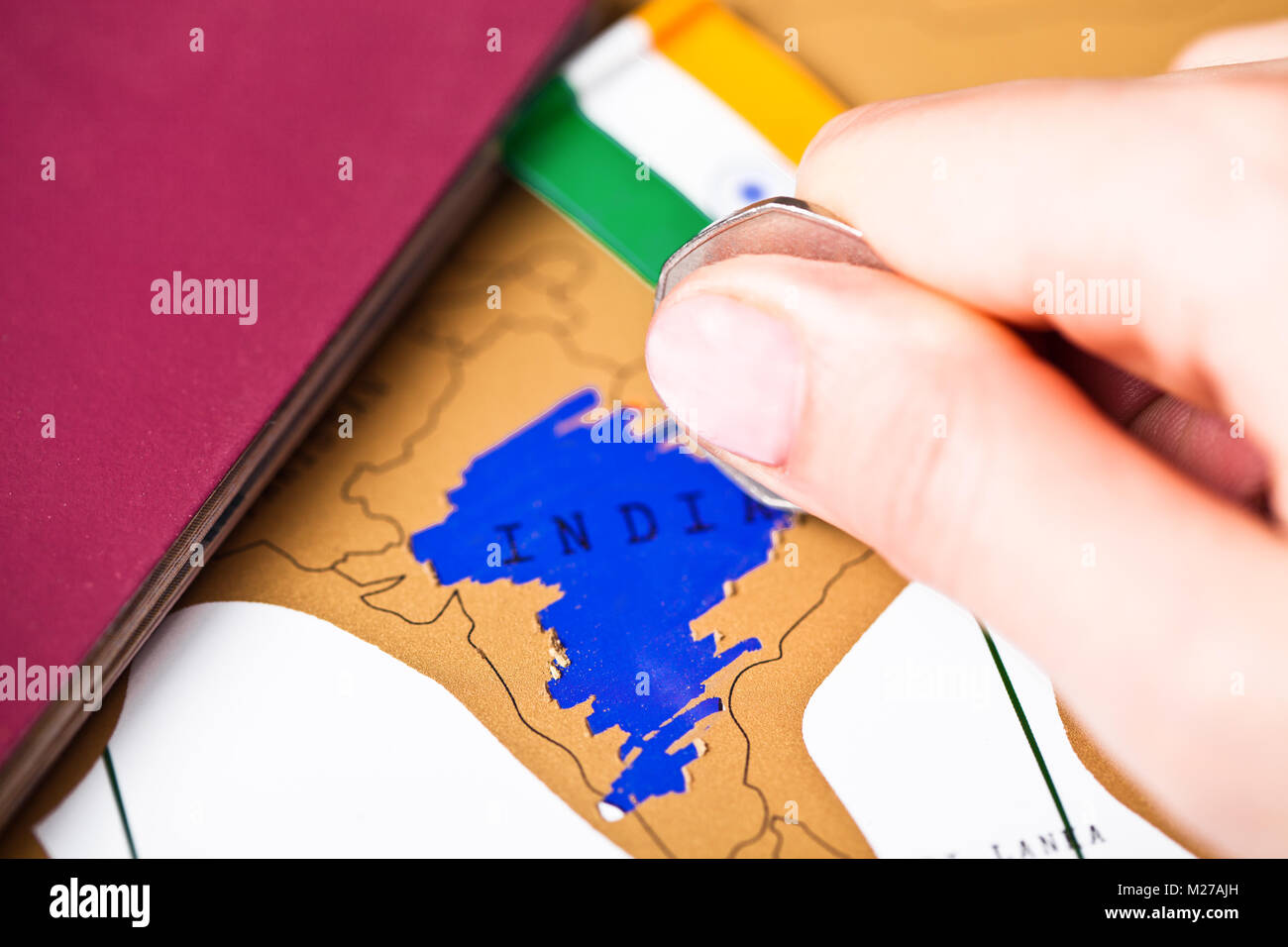 Travel holiday to India concept with passport and flag with female hand choosing India on the map Stock Photo