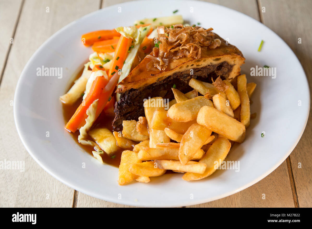 Steak and ale pie served with chips. The dish is a popular British pub meal  Stock Photo - Alamy