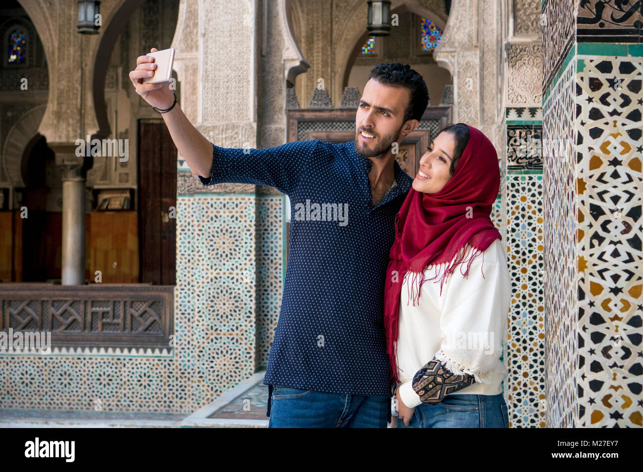 Arab couple smiling and taking selfie with mobile phone Stock Photo