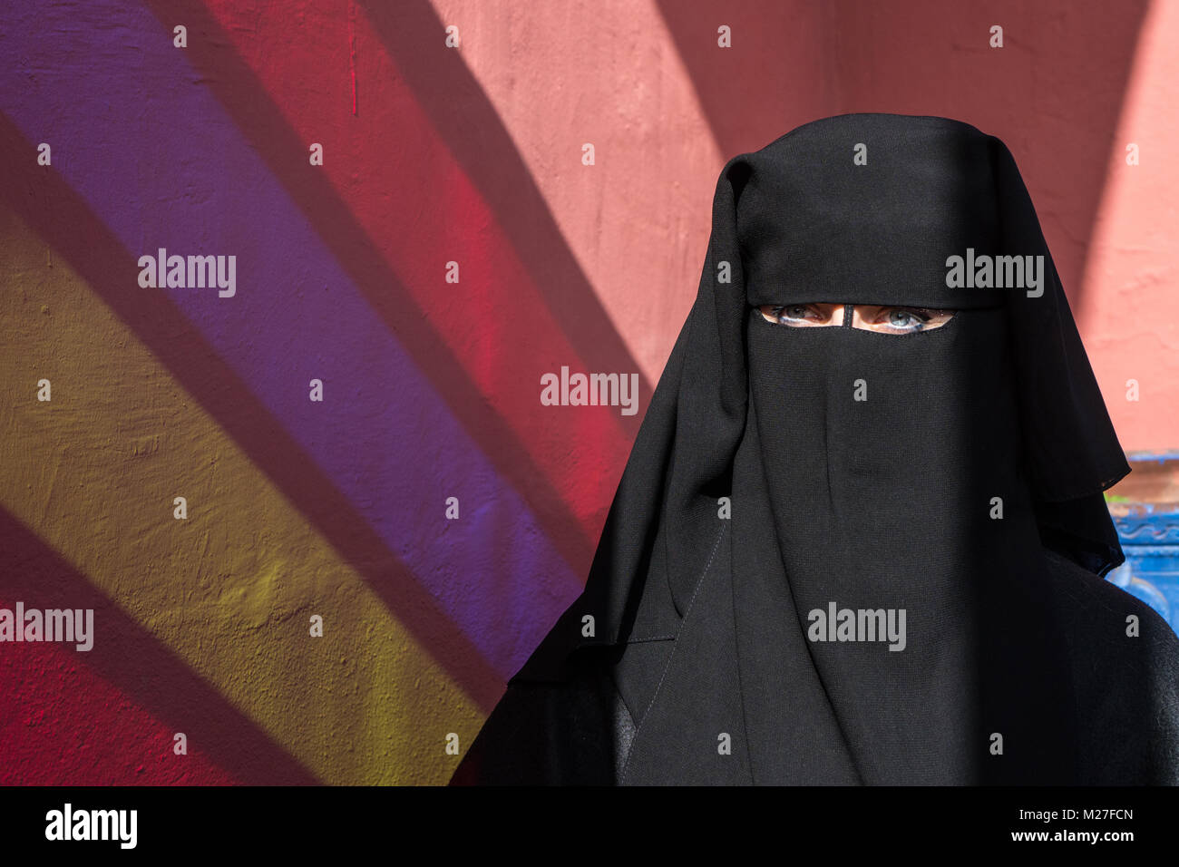 Arab woman with blue eyes with face covered with black niqab Stock Photo