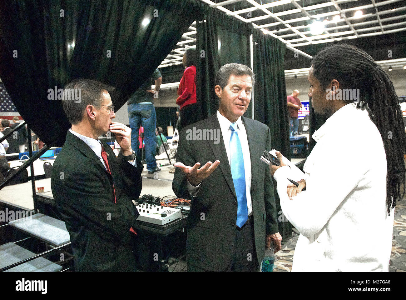 Topeka, Kansas, USA, 4th November, 2014 Newly re-elected Kansas Governor Sam Brownback at the Republican party victory watch party in Topeka. Standing by the Governor while he talks with reporter John Eligon of the NYT is his spokesperson John Milburn. Stock Photo