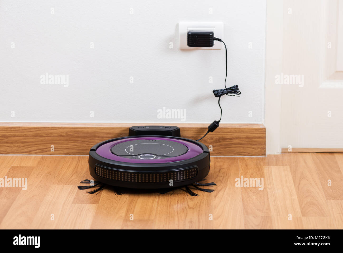 robotic vacuum cleaner charging battery at charging dock Stock Photo