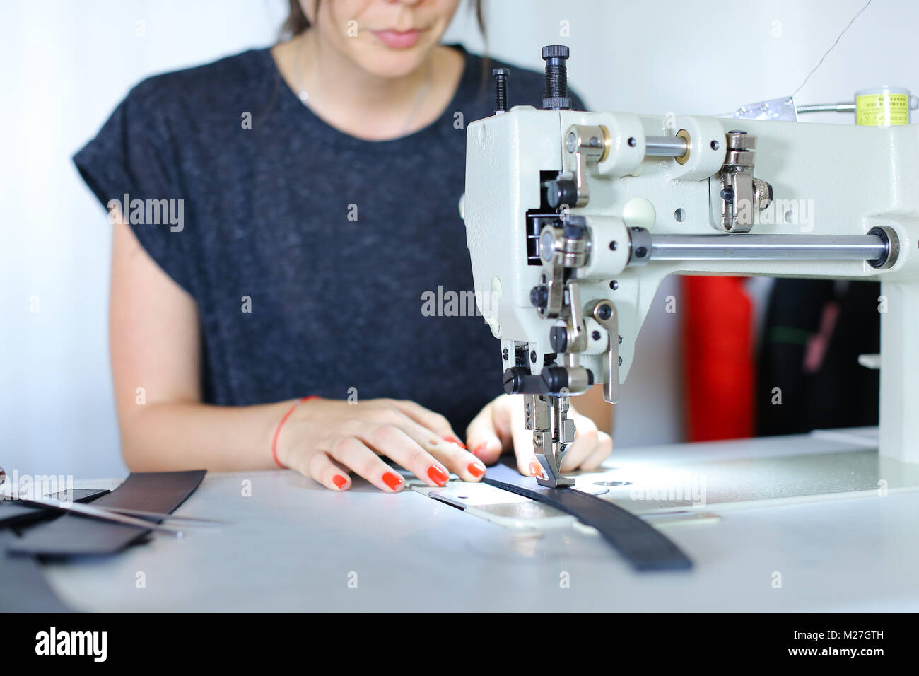 Seamstress sewing belt using sewing machine Stock Photo Alamy