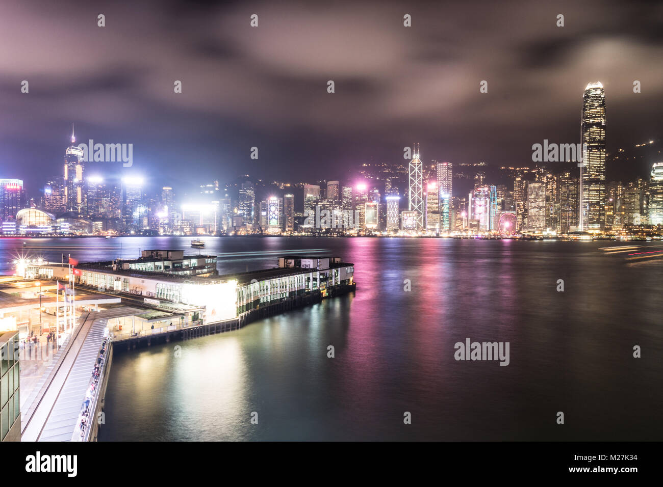 Stunning view of the Star Ferry pier in Tsim Sha Tsui in Kowloon and the Hong Kong island famous skyline across the Victoria harbour in Hong Kong at n Stock Photo