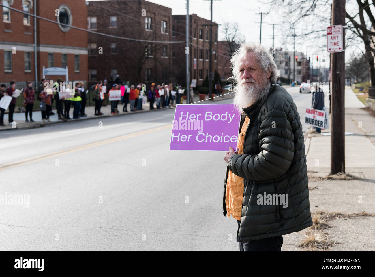 Cincinnati, Ohio, USA. February 11th 2017 A pro planned parenthood protestor holds a sign saying 'Her Body. Her Choice' Out of focus to the left are more pro Planned Parenthood protesters. Behind the subject is a anti abortion protestor. Credit:  Caleb Hughes/Alamy Live News. Stock Photo