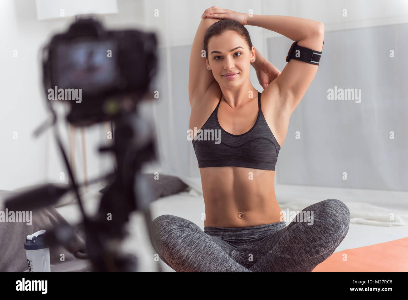 Exuberant young blogger doing exercises for camera Stock Photo