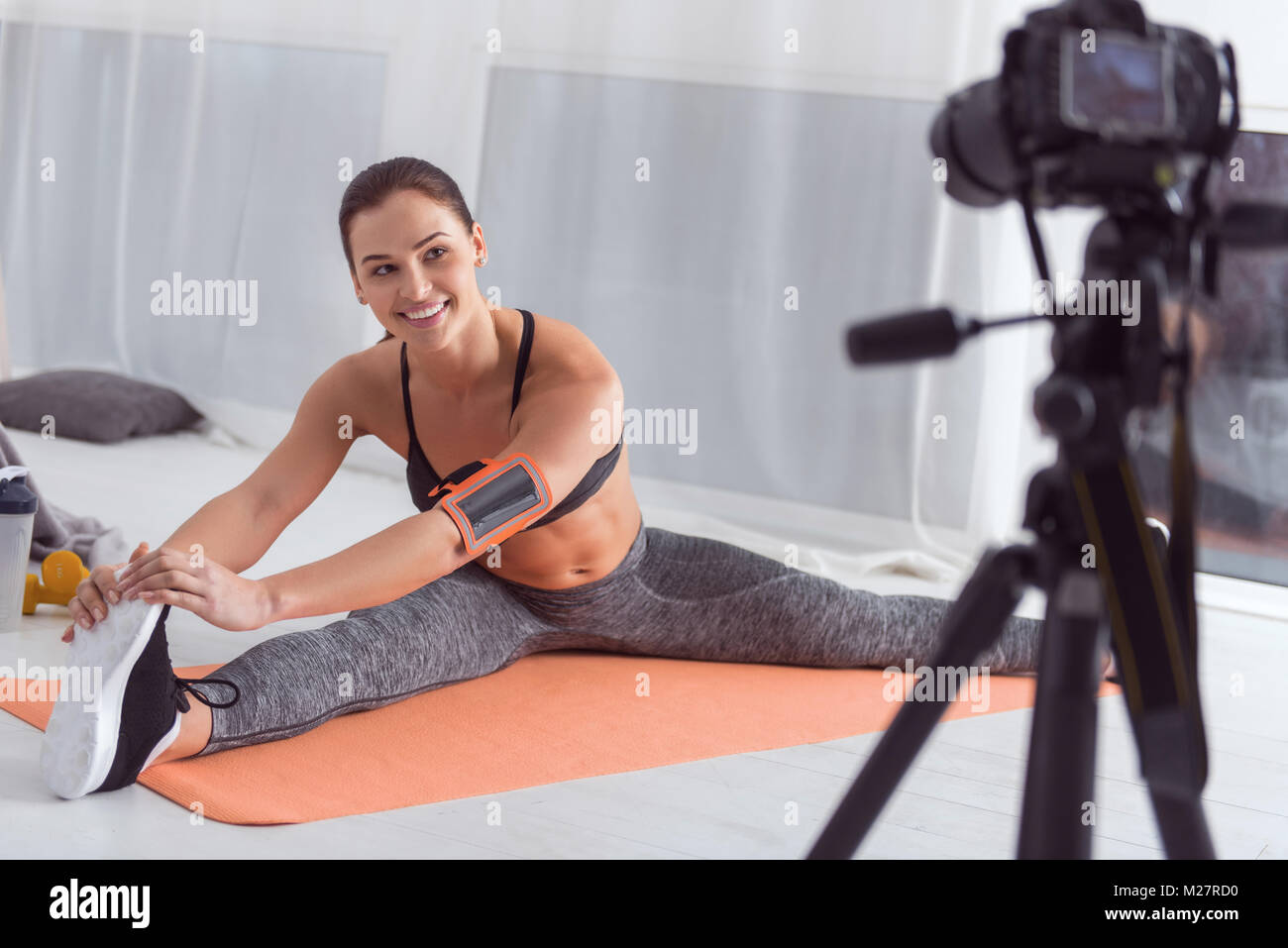 Happy sports blogger doing exercises for camera Stock Photo