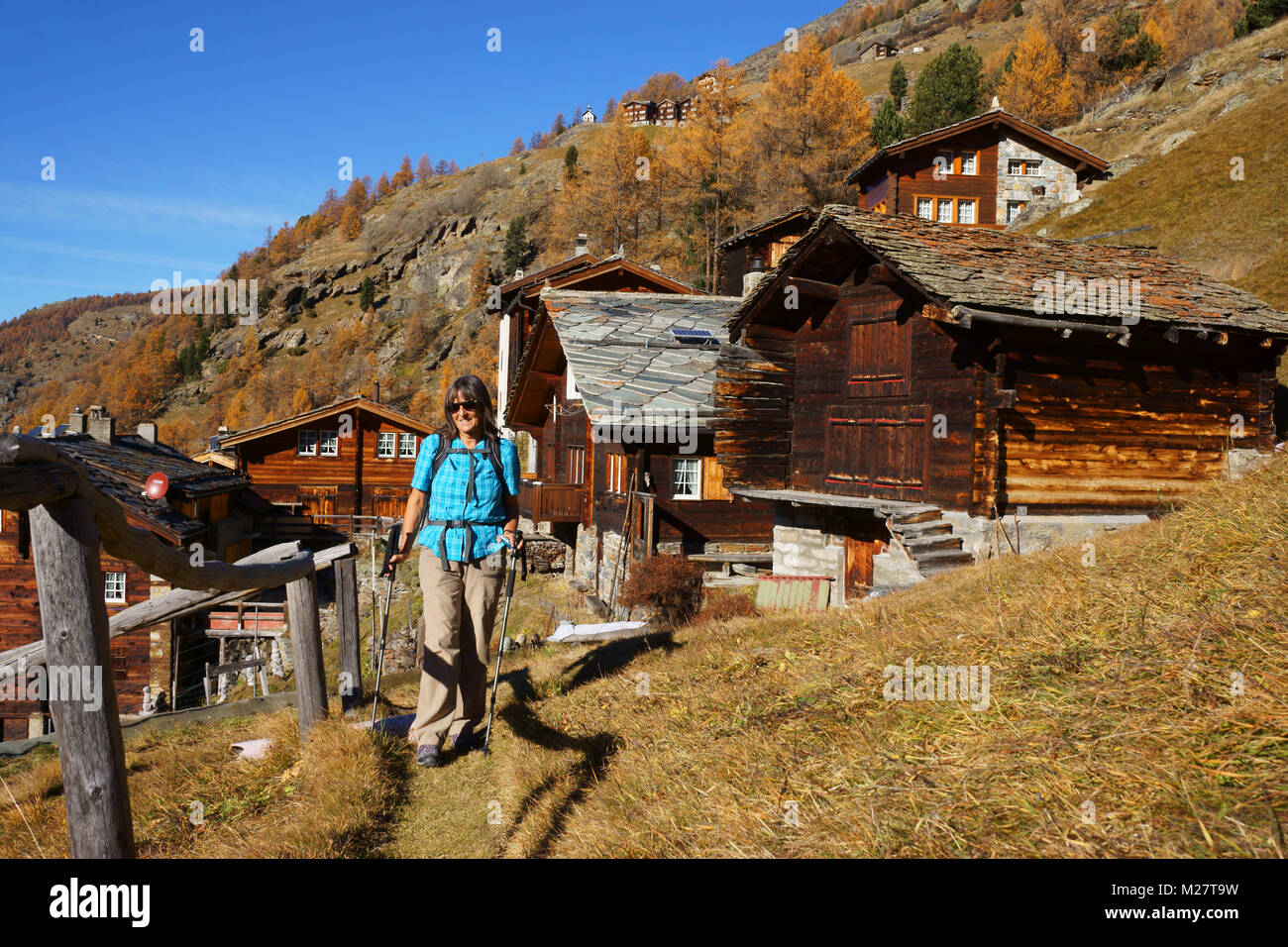 Hiker at Unneri Brend village along Gspon-Saas Grund 'Höhenweg', fall, Valais, Switzerland Stock Photo