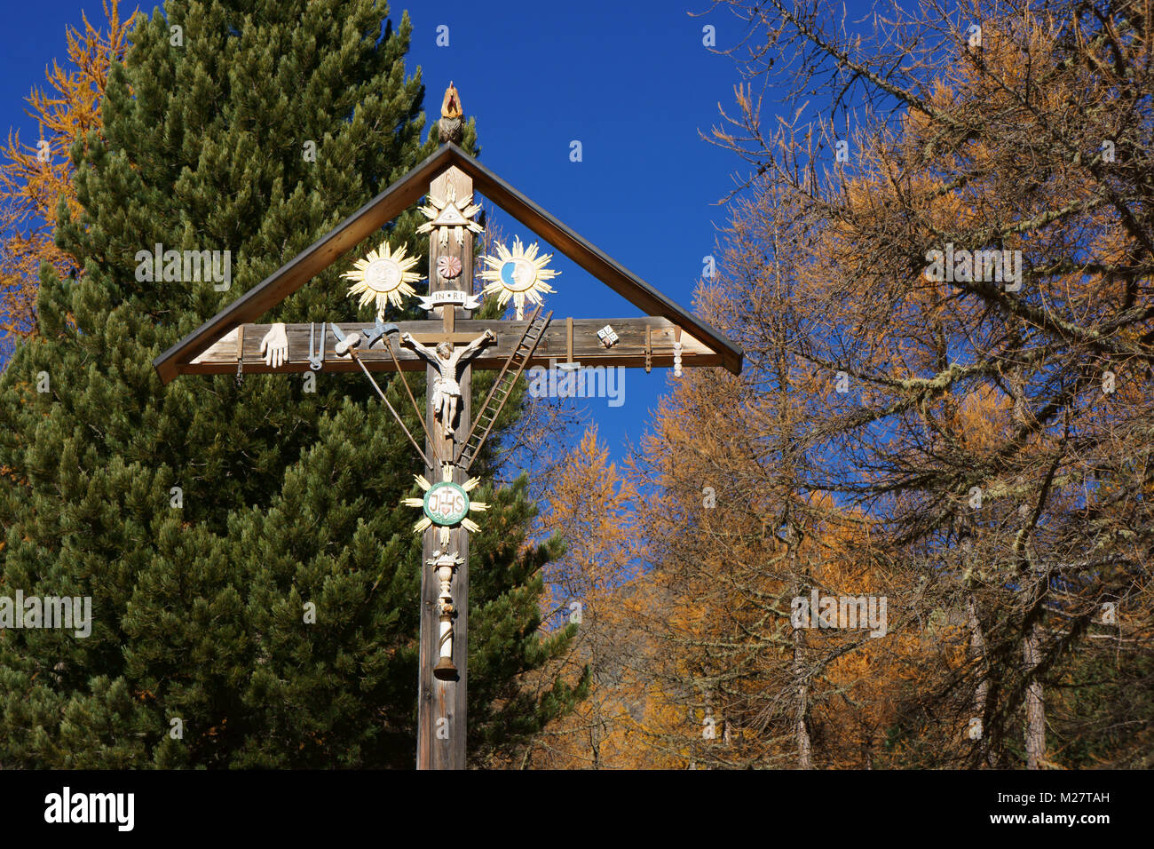 Cross with Jesus figure and torture tools decorated, Saas grund, Valais alps, Switzerland Stock Photo