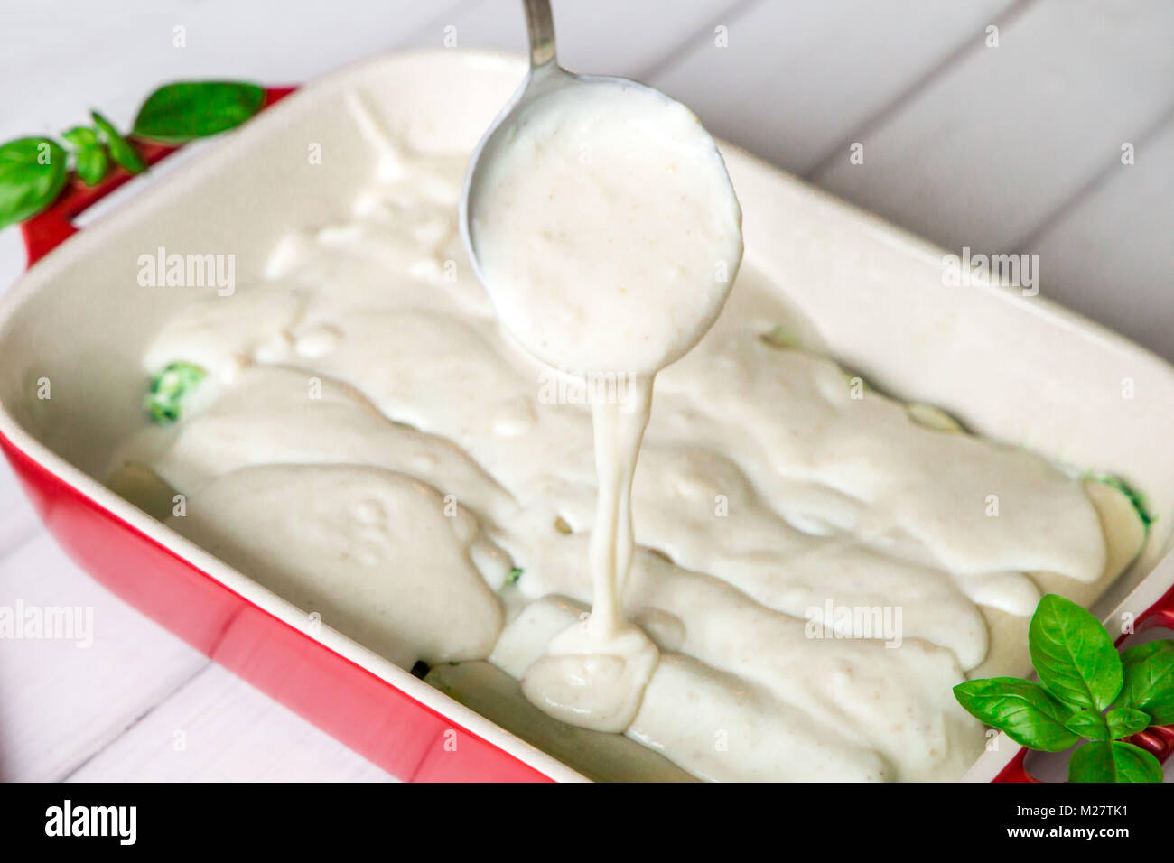 closeup of Pouring bechamel sauce on cannelloni. Stock Photo