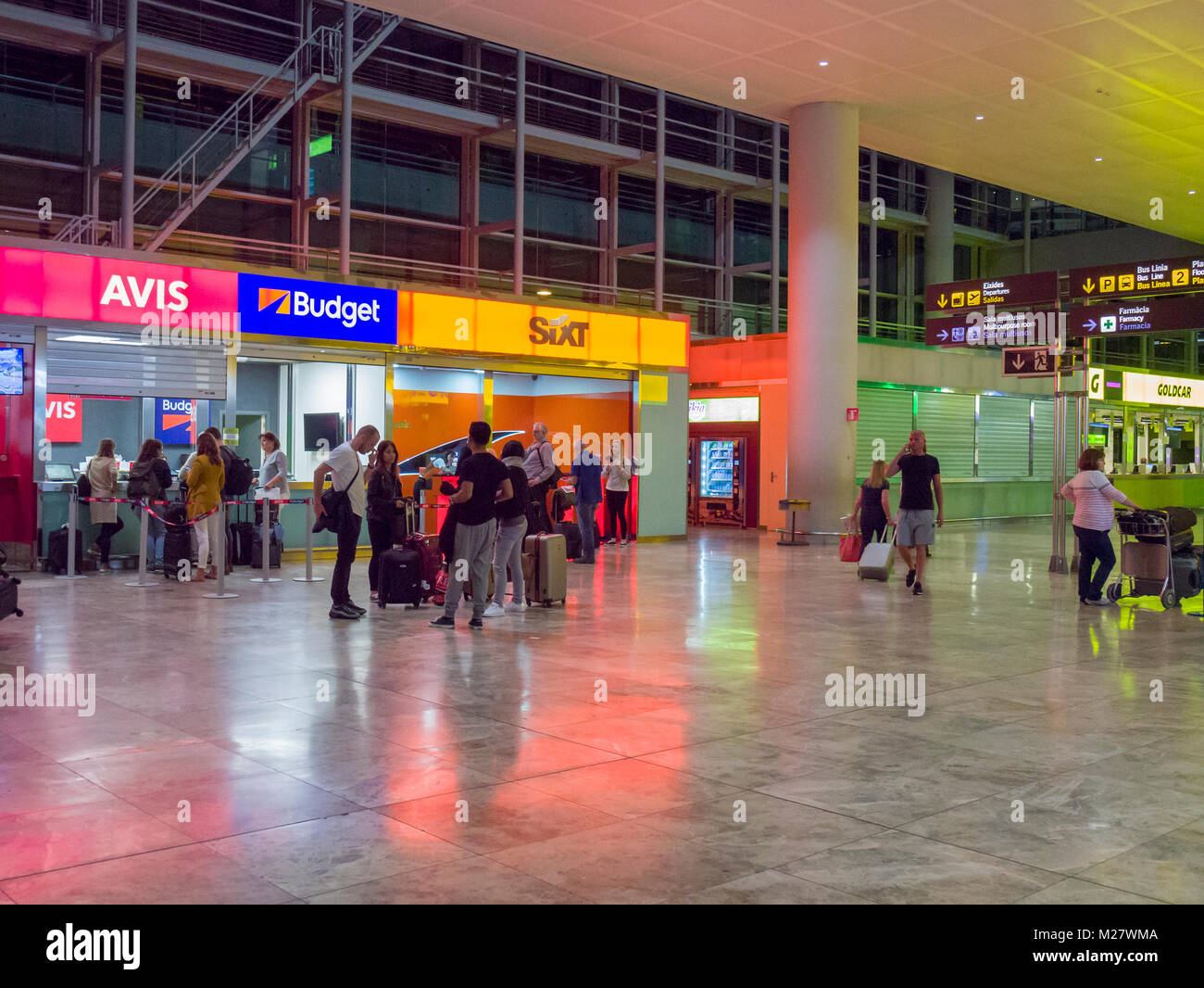 Car rental booths in the arrivals hall at Alicante Airport at night. Alicante, Spain. Stock Photo