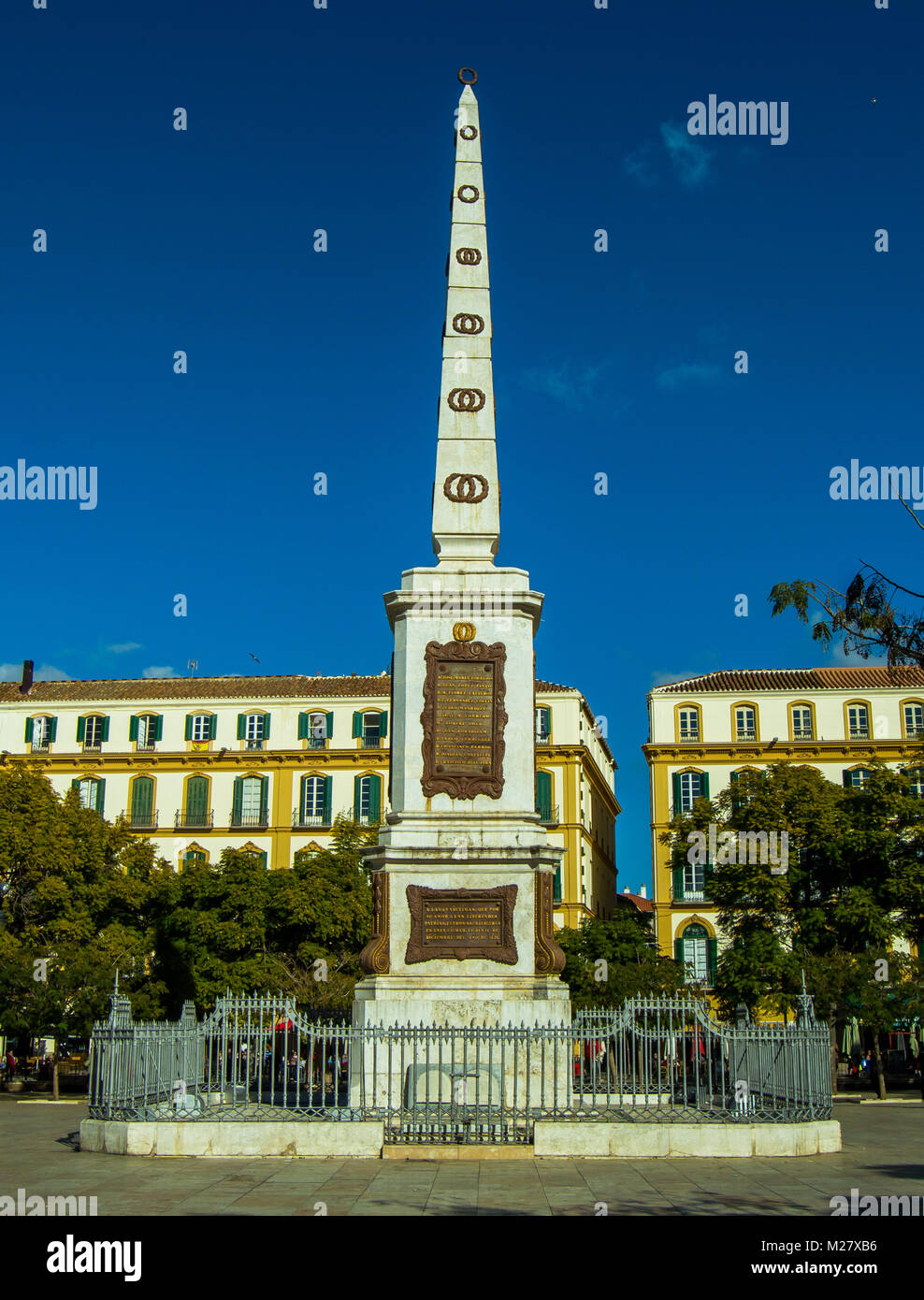 Views of the monument to Torrijos and buildings. Huge obelisk located in the Plaza de la Merced, birthplace of Picasso. December 2017, Málaga, Spain. Stock Photo