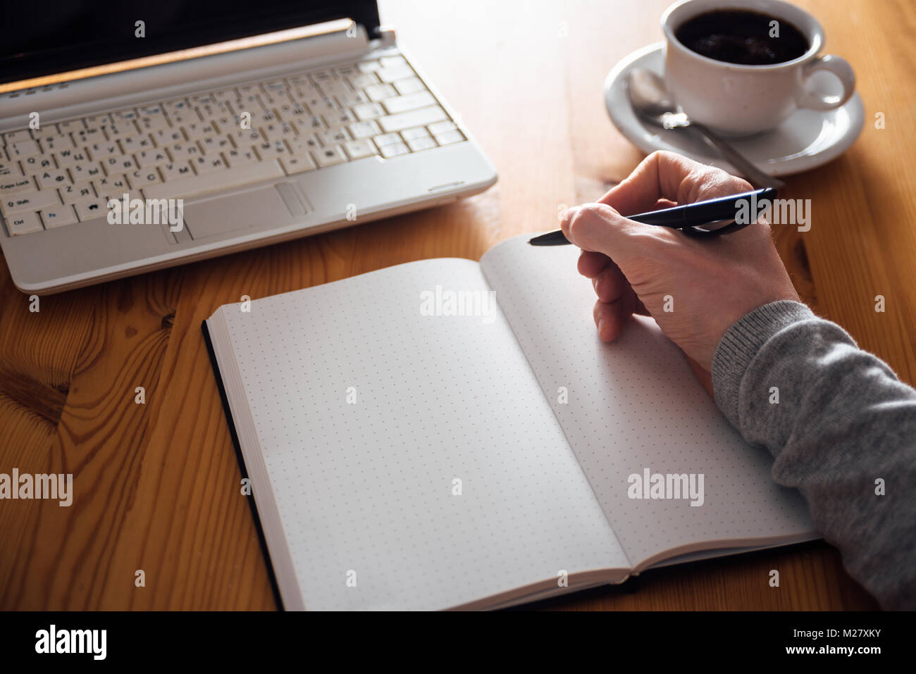 Man hand writing in planner. Coffee, laptop on background Stock Photo ...