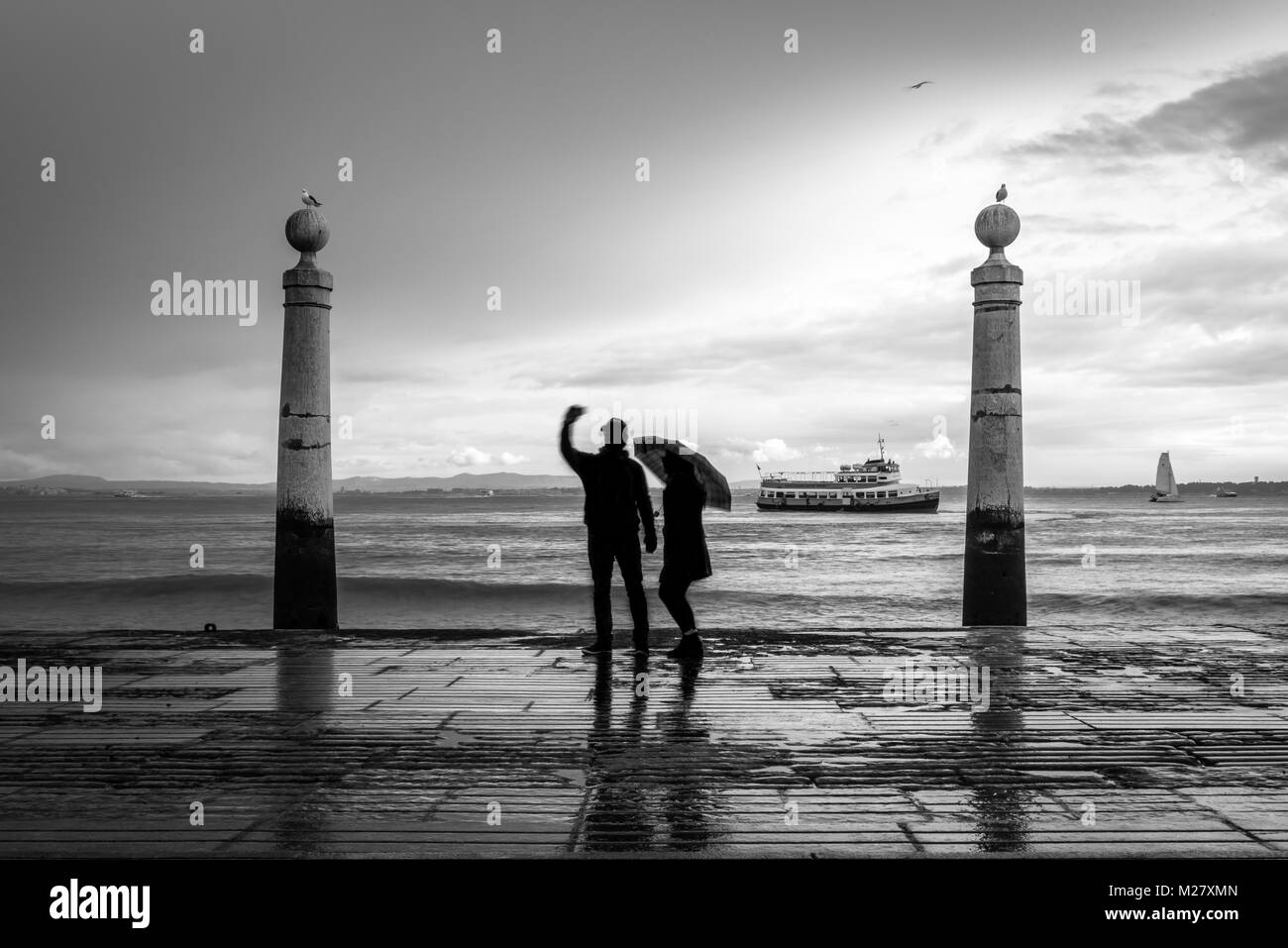 Couple on Tagus River shore, Love in Lisbon - Cais das colunas Stock Photo