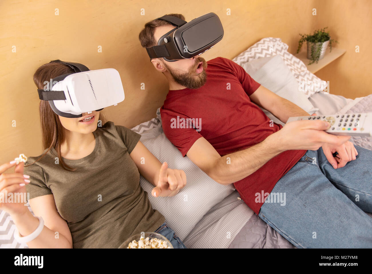 Charming pleased couple listing VR films Stock Photo