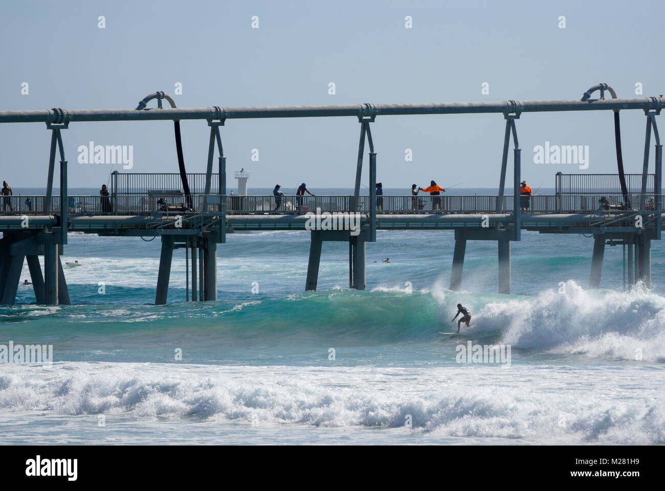 Surfing and fishing at The Spit, on the Gold Coast in Australia. Stock Photo