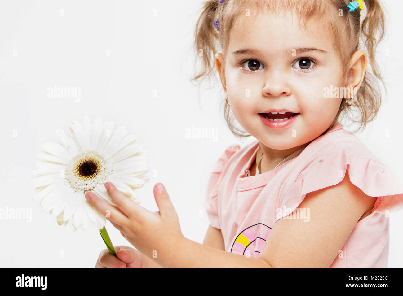 Portrait of a beautiful little cheerful girl on a white background. The ...
