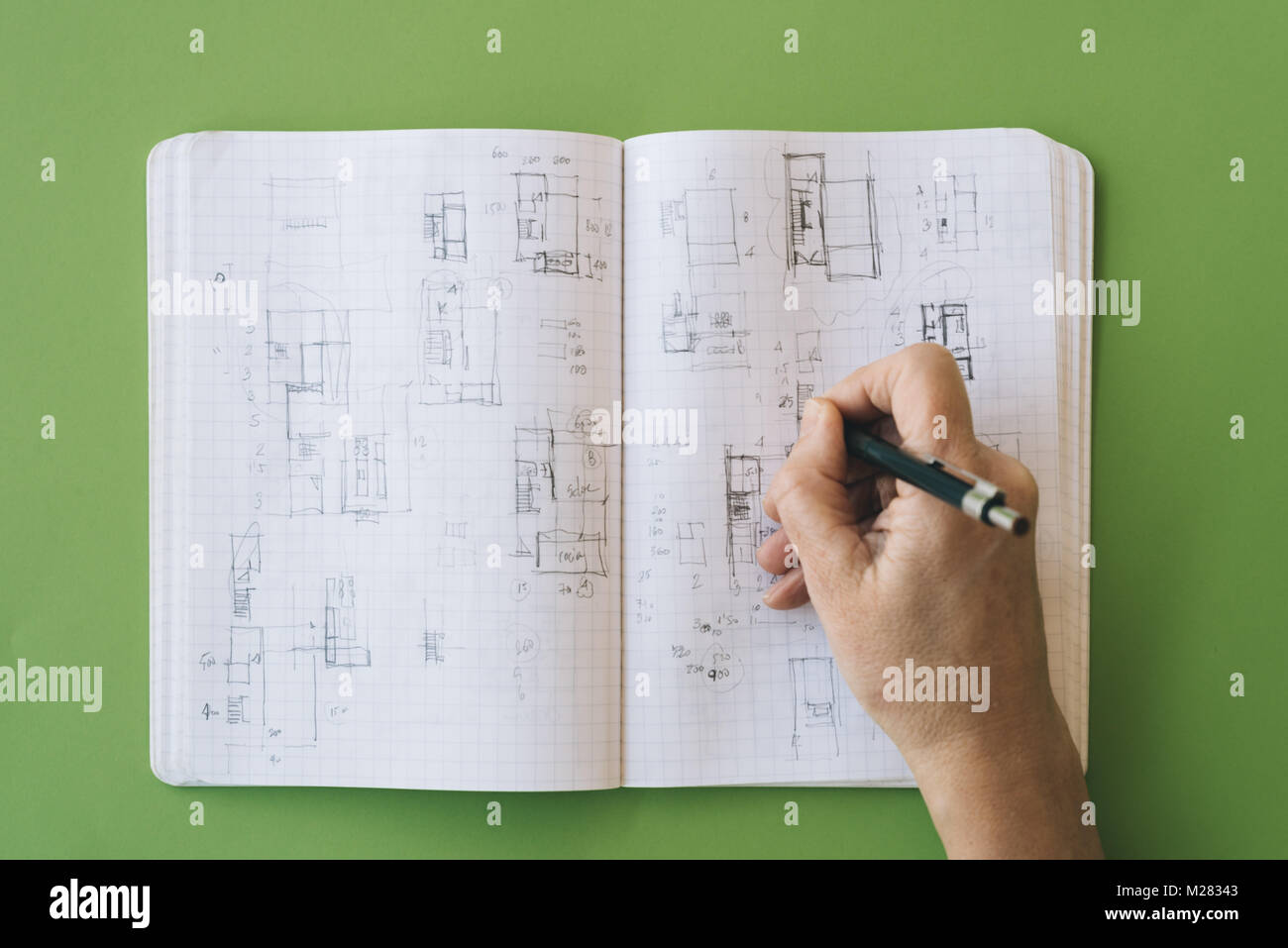 Architect works drawing sketches on notebook on green background. Flat
