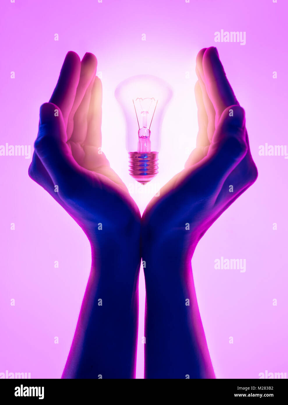 Female hands and holding luminous light bulb. Electric incandescent