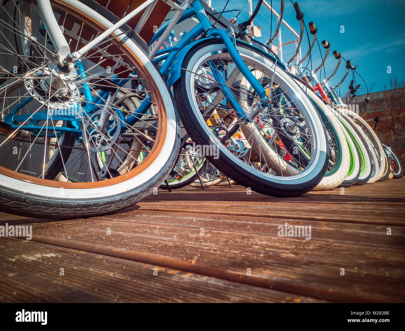 Many bikes in a row on the street. Bicycle parking. Colored bicycles on the street Stock Photo