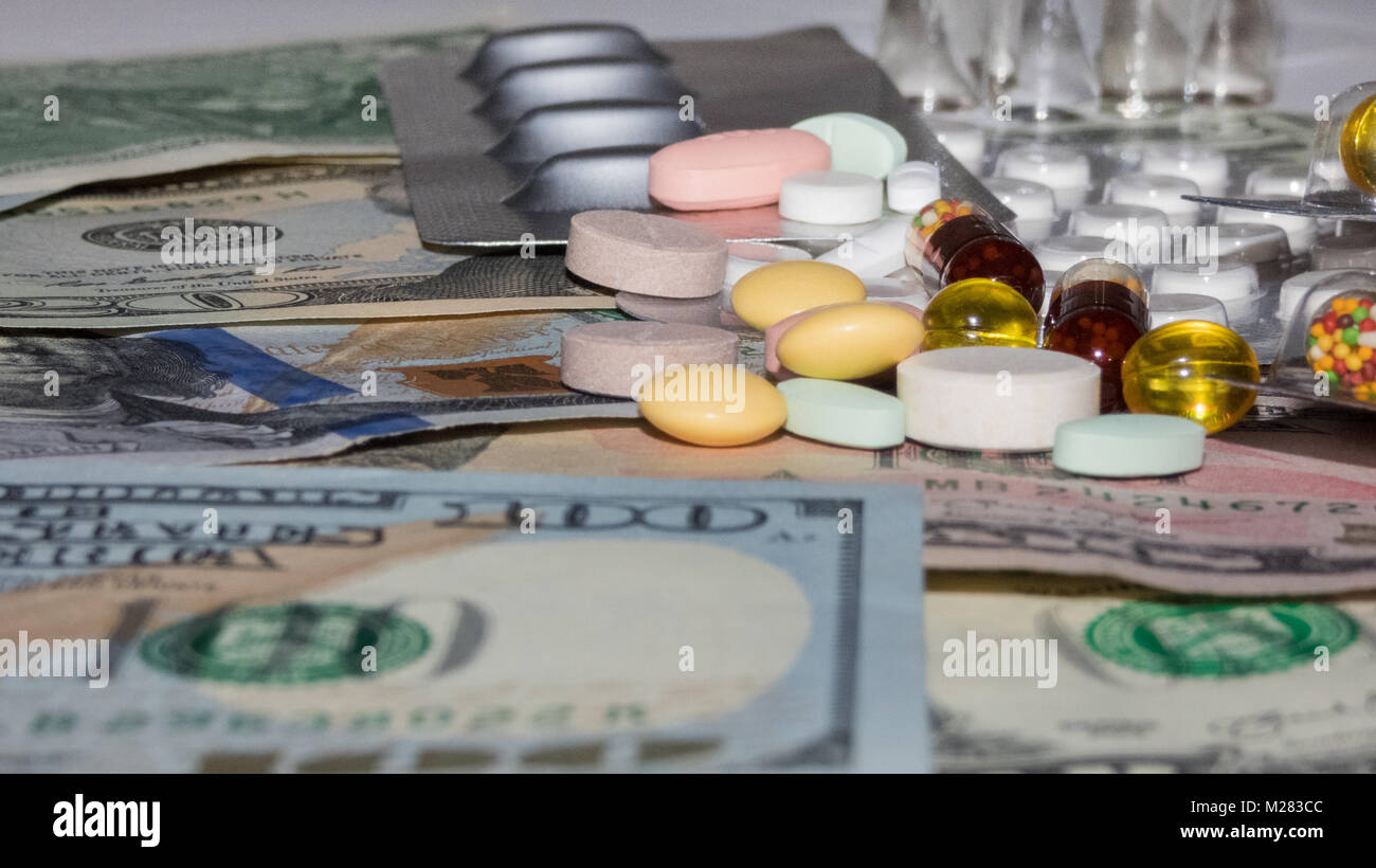 a bunch of pills of different colors on a dollars, blurry photos Stock Photo