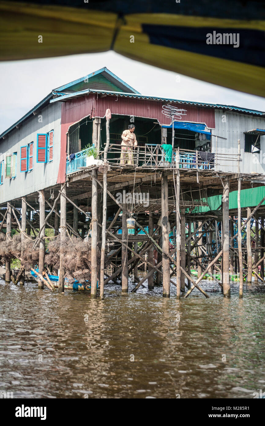Cambodian hoisting bucket of water to house on stilts, Kampong Phluk