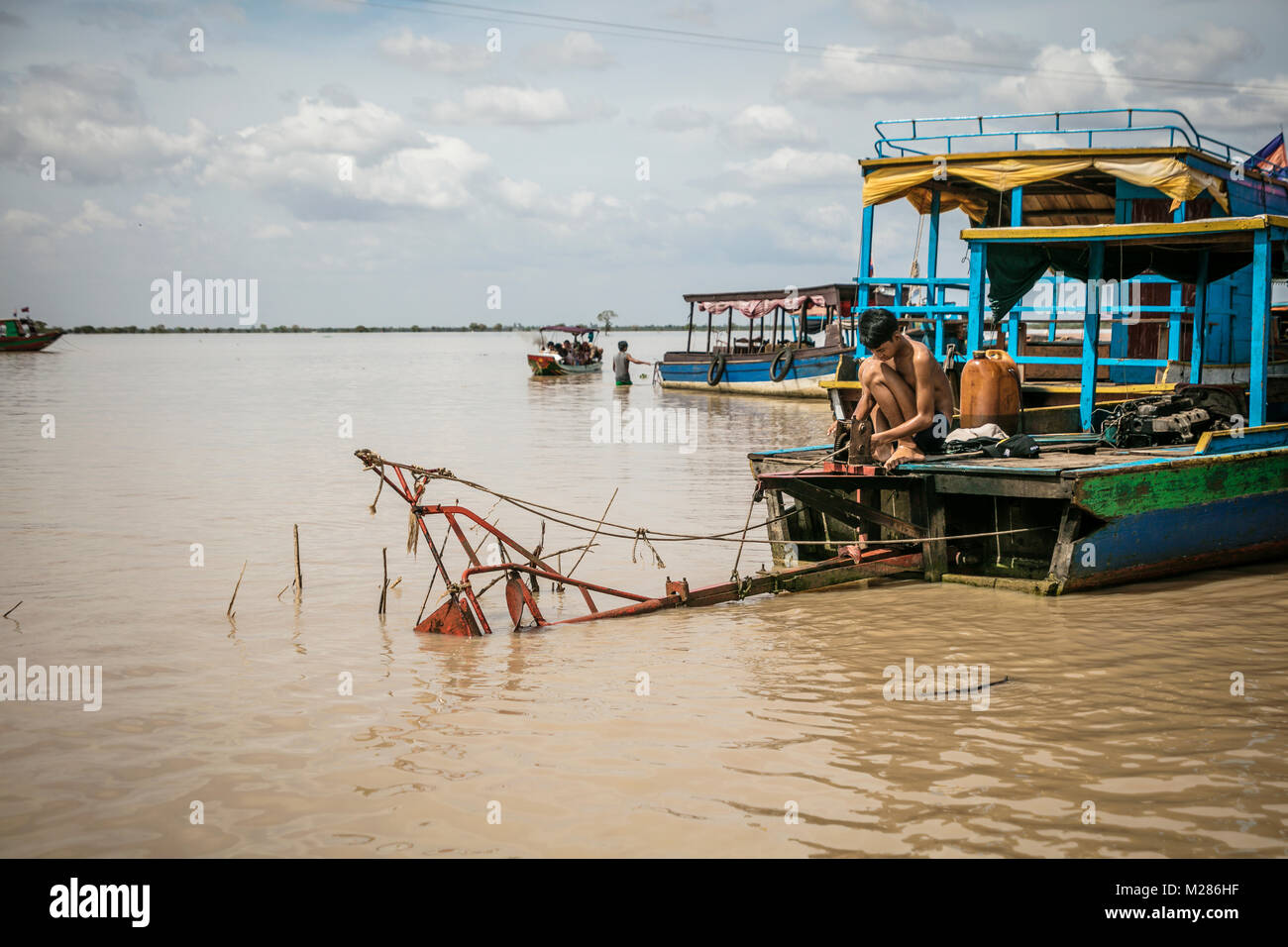 Cambodian raising propeller shaft from water on tourist boat, Kampong Phluk Floating Village, Siem Reap Province, Cambodia. Stock Photo