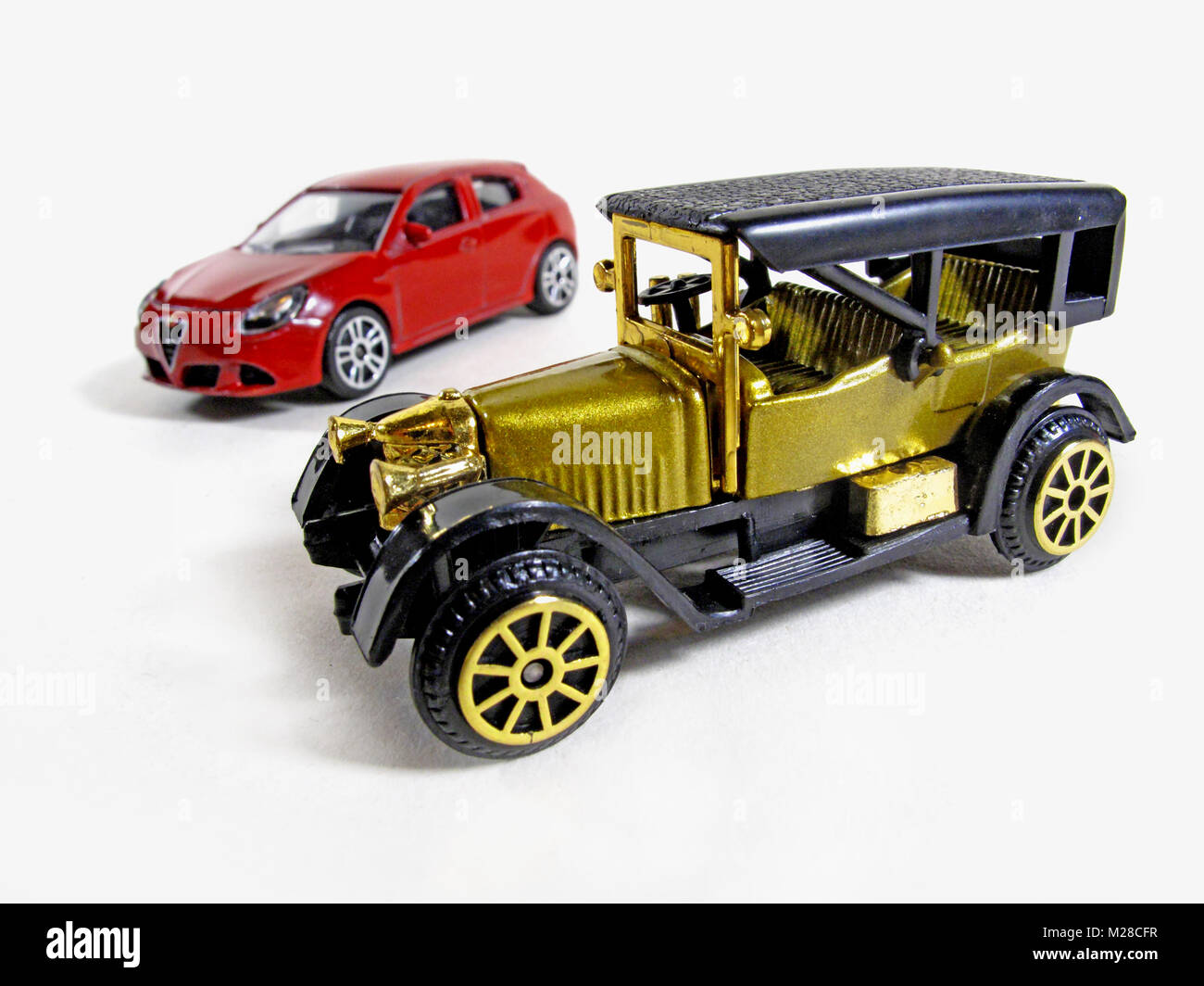 contrast of an old vintage toy car with a modern one. Stock Photo