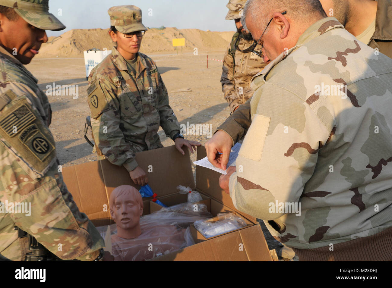 U.S. Army Sgt. Chadwick Dile, left, and 1st Lt. Grisel Davila, center, both assigned to the 536th Support Maintenance Company, 275th Combat Sustainment Support Battalion, display a mannequin to an Iraqi army leader during a medical equipment transfer at the Besmaya Range Complex, Iraq, Jan. 28, 2018.  The U.S. provides training and equipment to vetted Iraqi security forces through the National Defense Authorization Act FY 2015; Iraq Train and Equip Fund. Training and equipment is in support of the Combined Joint Task Force – Operation Inherent Resolve mission to defeat and deny ISIS safe haven Stock Photo