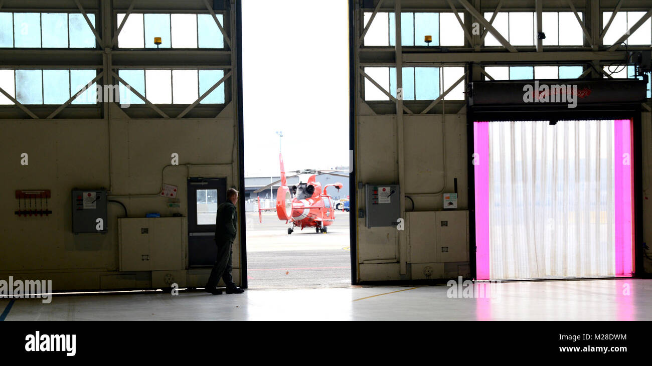 Petty Officer 3rd Class Dylan Melton, a flight mechanic, closes a hangar door in Washington D.C., Jan. 30, 2018. Crews from Air Station Atlantic City support the National Capital Region Air Defense Facility (NCRADF) by supplying multiple aircraft to assist the North American Aerospace Defense Command (NORAD). U.S. Coast Guard Stock Photo