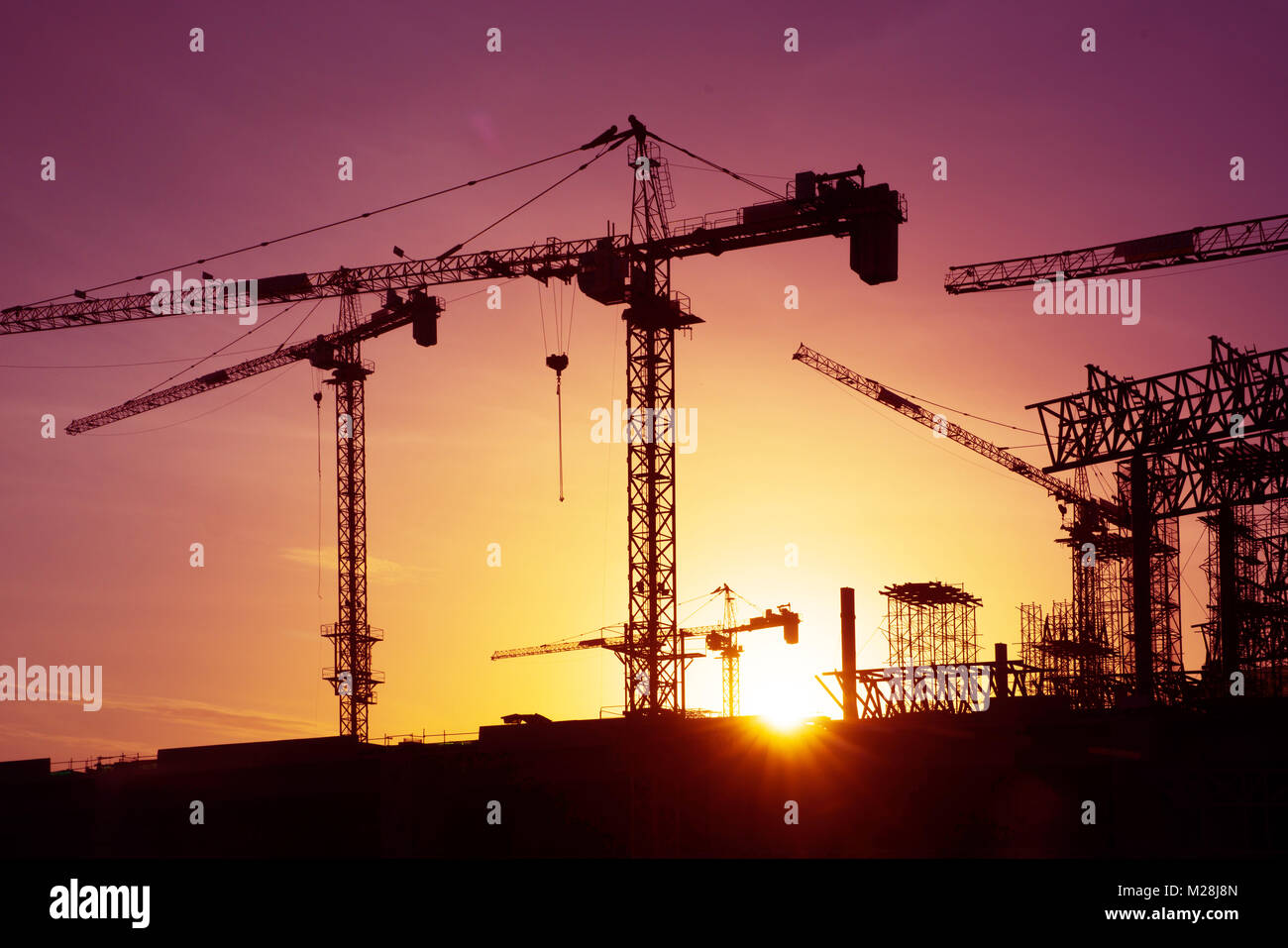 construction crane over tower building site silhouette sunrise ...