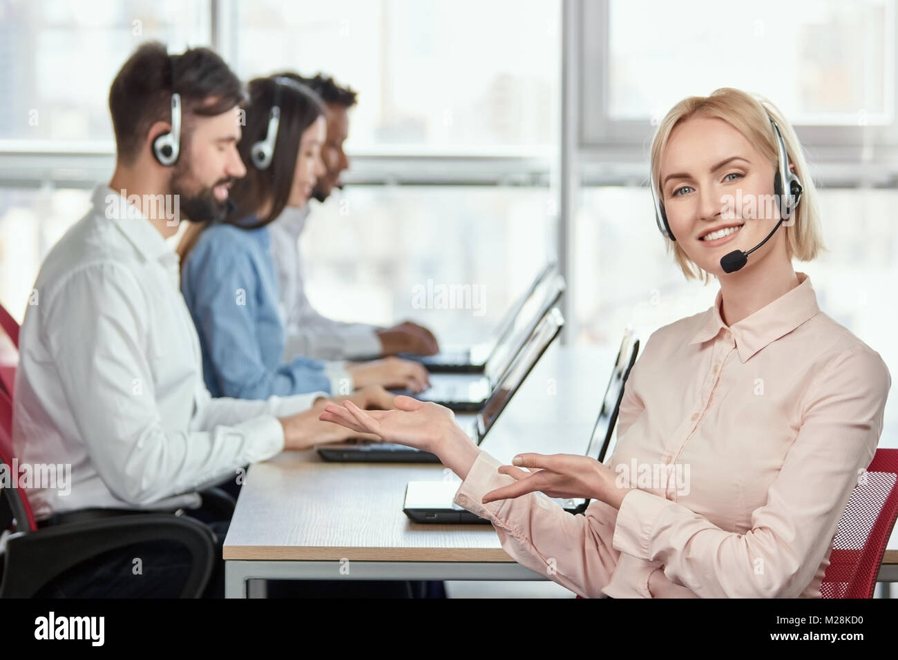 Female operator recommeding her co-workers. Lady with headset in call ...