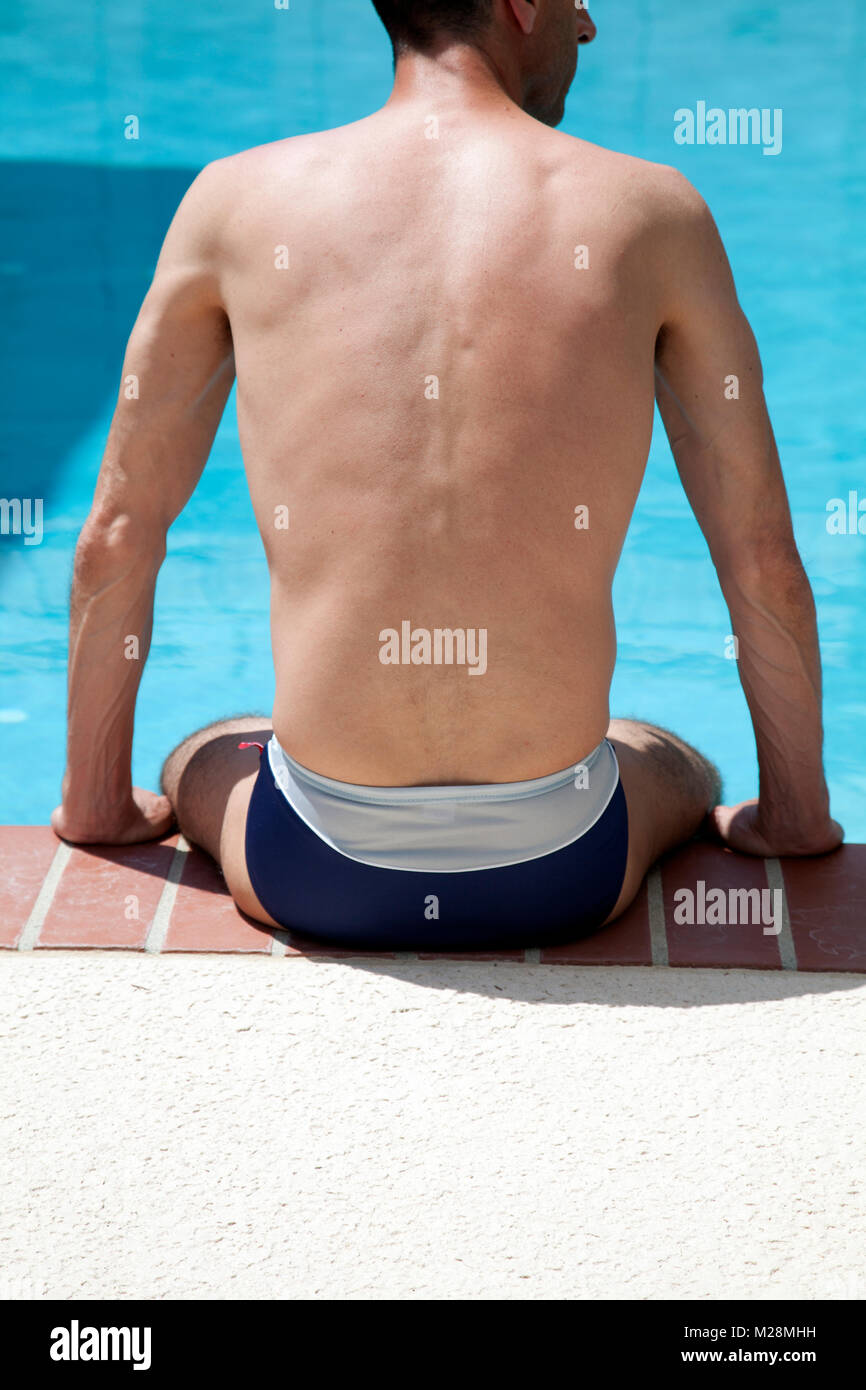Man in Speedo Sitting at Edge of Swimming Pool Stock Photo - Alamy