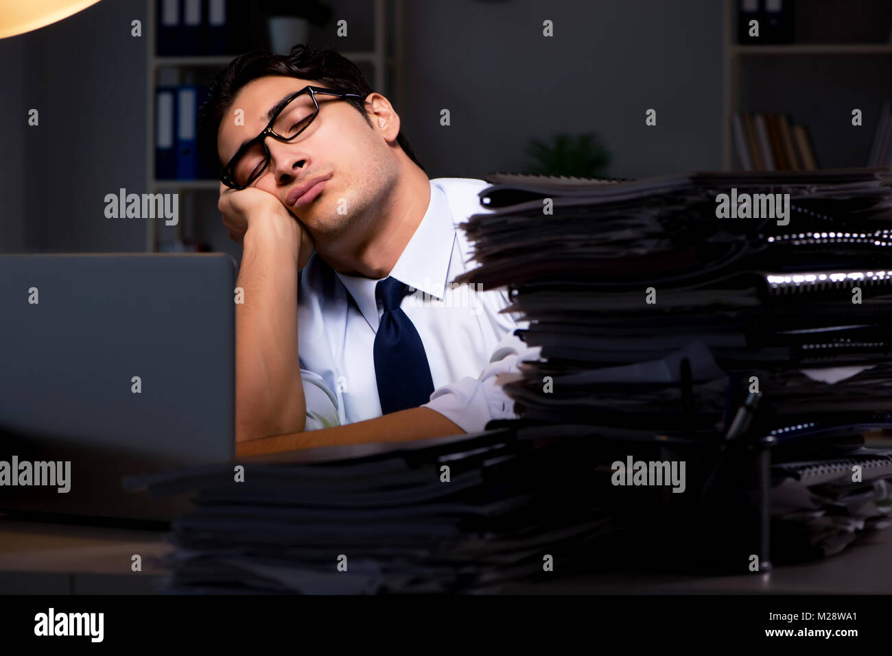 Young businessman working overtime late in office Stock Photo - Alamy