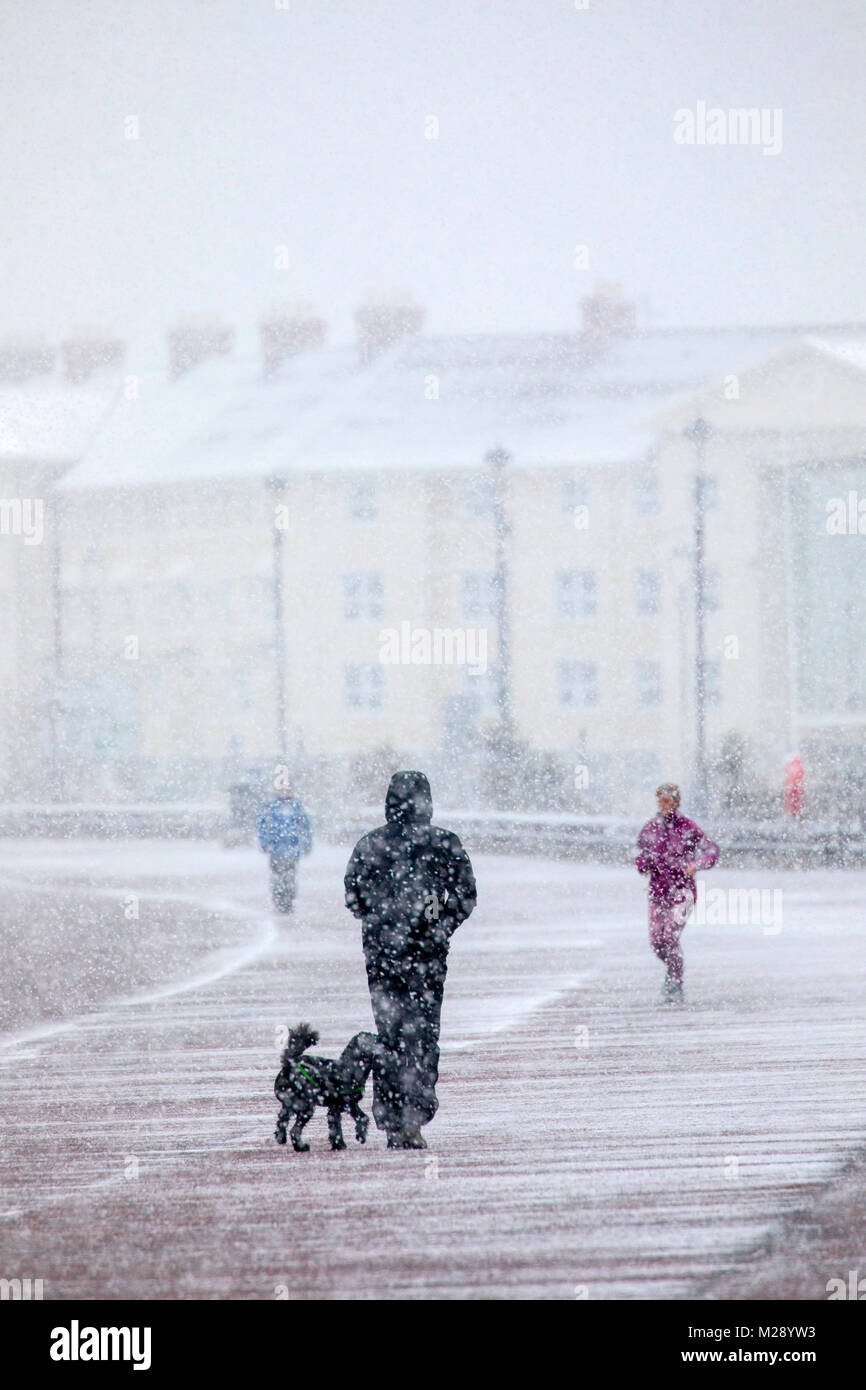 Llandudno, Wales, 6th February 2018. UK Weather. As predicted a yellow warning for snow for North Wales today with some parts receiving up to 8cm on higher ground. Very unusual snow for the coastal resort of Llandudno in North Wales as people discovered on the seafront promenade  © DGDImages/Alamy Live News Stock Photo