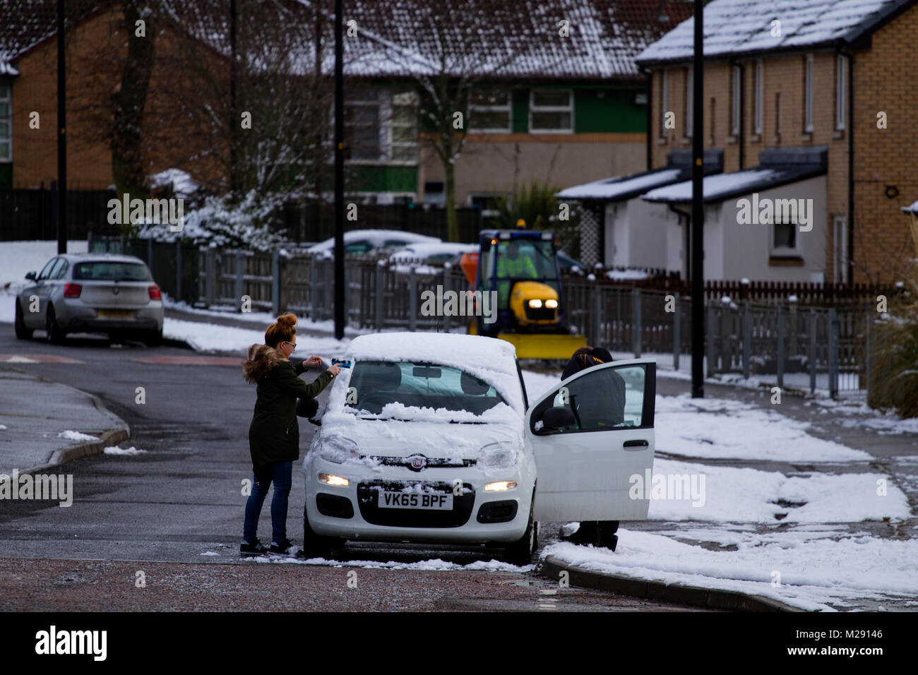 Dundee, Scotland, UK. 6th February, 2018. UK weather: Freezing temperatures brings overnight snow across North East Scotland. A woman scraping the snow off her car in Ardler Village housing Estate in Dundee, UK: Credits: Dundee Photographics/Alamy Live News Stock Photo