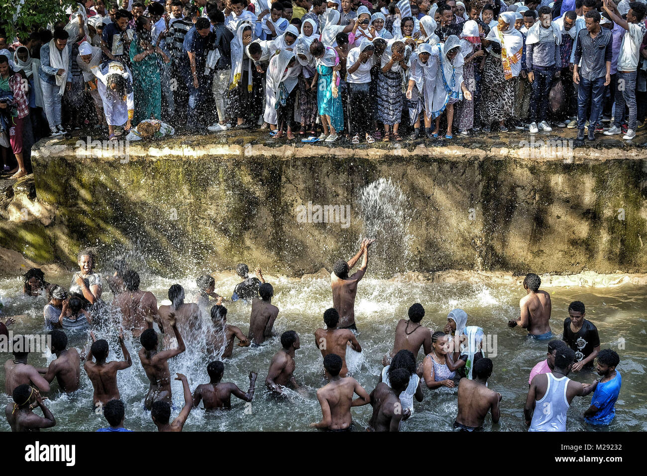 January 19, 2018 - Gondar, Amhara Region, Ethiopia - Pilgrims bathing in the waters of the Fasilides Baths..The annual Timkat festival, an Orthodox Christian celebration of Epiphany, remembers the baptism of Jesus in the Jordan river. During the festival, tabots, models of the Ark of the Covenant, are taken from churches around the city of Gondar and paraded through the streets to Fasilides Bath. Where finally the pilgrims end up bathing in the water blessed by the priests. (Credit Image: © Oscar Espinosa/SOPA via ZUMA Wire) Stock Photo