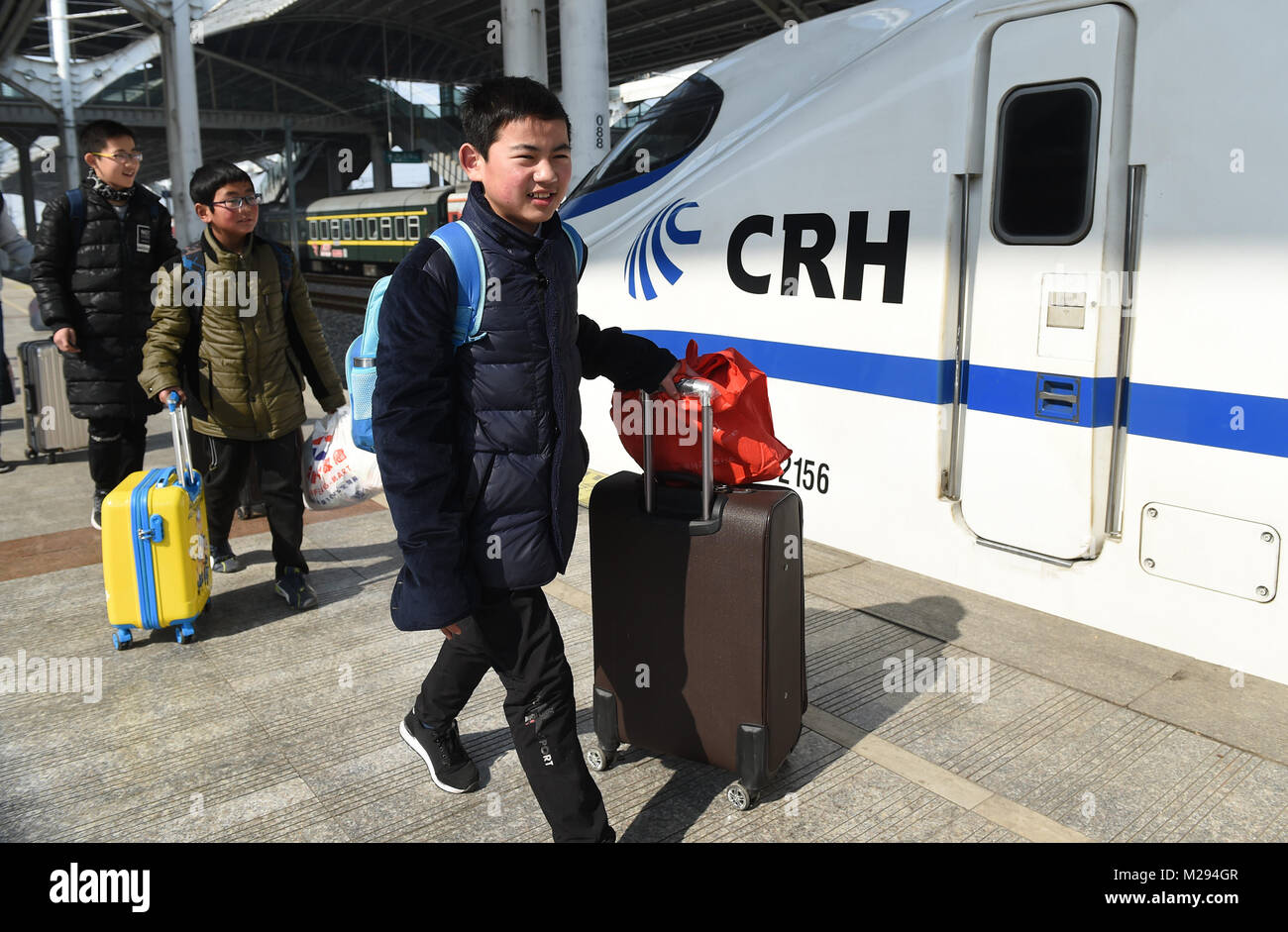 (180206) -- ON BOARD K419, Feb. 6, 2018 (Xinhua) -- Sun Jianjun (1st R) and his schoolmates walk on the platform of the railway station of Nantong, in east China's Jiangsu Province, Feb. 1, 2018. Spring Festival, or Chinese Lunar New Year, falls on Feb. 16 this year. Hundreds of millions of Chinese will return to their hometowns for family gatherings. 14-year-old Sun Jianjun and his 15 schoolmates are among these travellers eager back to home. On Feb. 1, the first day of the 2018 Spring Festival travel rush, they stepped onto a train in Nantong of east China's Jiangsu Province on a journe Stock Photo
