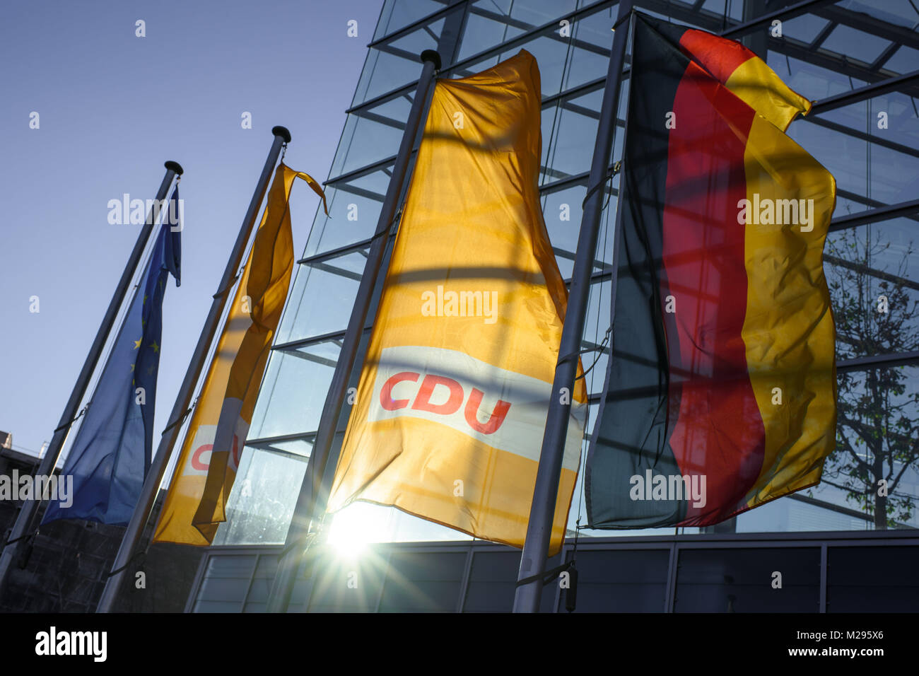 The Europe flag (L-R), two flags of the Christian Democratic Union party (CDU) and a Germany flag blowing in the wind in front of the party headquarters of the CDU, the Konrad Adenauer house, in Berlin, Germany, 06 Febuary 2018. The coalition negotiations of the Christian Democratic Union (CDU), Christian Social Union (CSU) and the Social Democratic Party (SPD) are taking place there today. Photo: Gregor Fischer/dpa Stock Photo