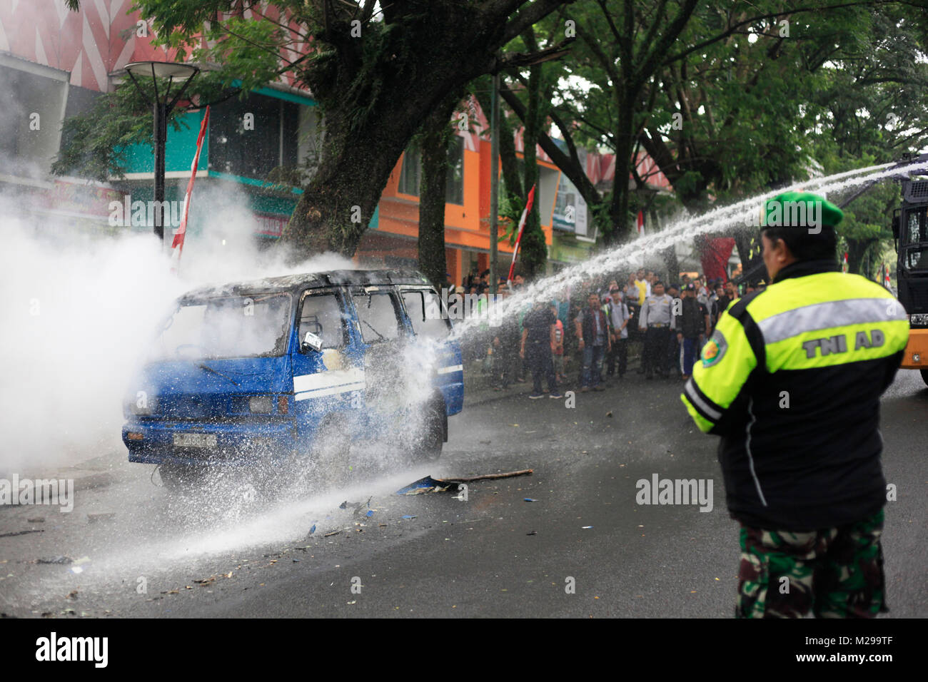 Bogor, West Java, Indonesia, 3 February 2018. Police officers extinguished the fire on a car that was burned by demonstrators during a simulation of the security of local elections, Bogor, West Java, Indonesia, 3 February 2018 Stock Photo