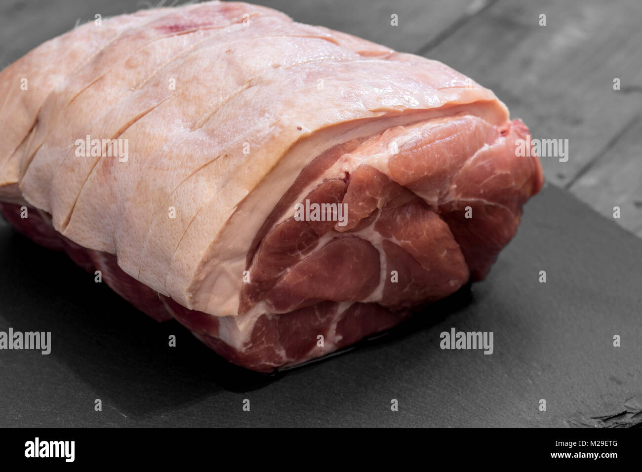 Raw pork joint of meat on slate with selective color Stock Photo Alamy