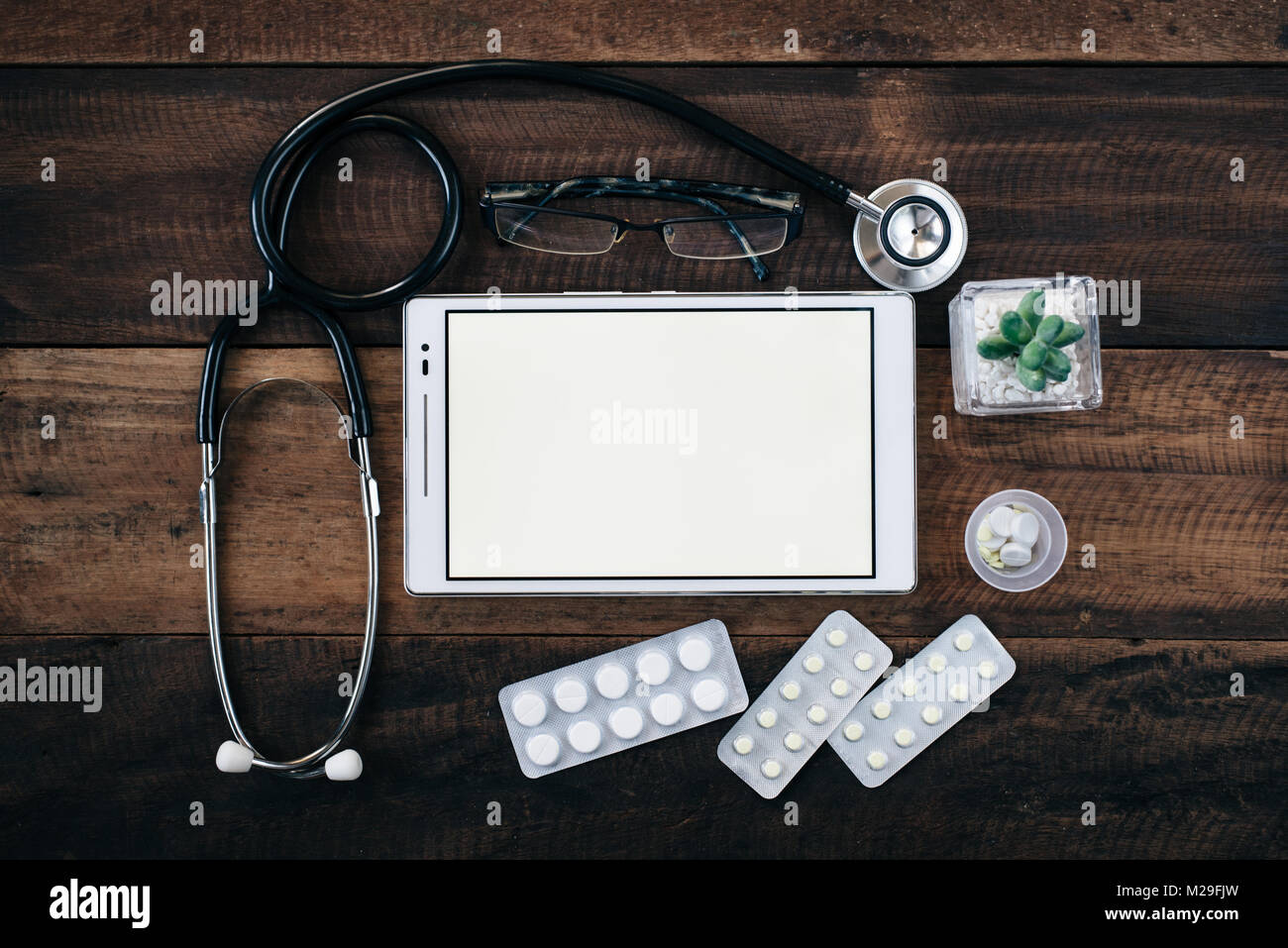 stethoscope, digital tablet and medicine on wooden table background ...