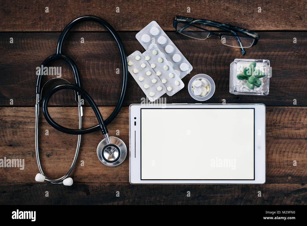 stethoscope, digital tablet and medicine on wooden table background ...