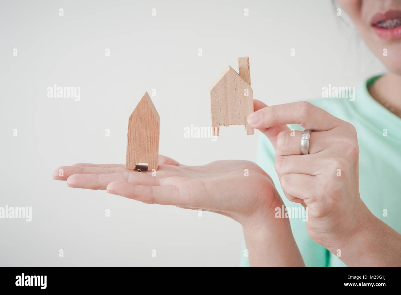 Woman hand showing small wood house model. Business, life growth, and dream plan for family concept Stock Photo