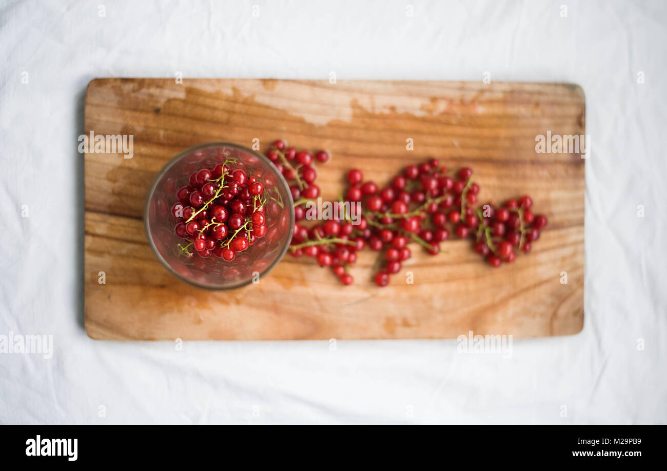 Red Currant in the Glass on Wooden Background. View from above. Seasonal Fruit. Stock Photo