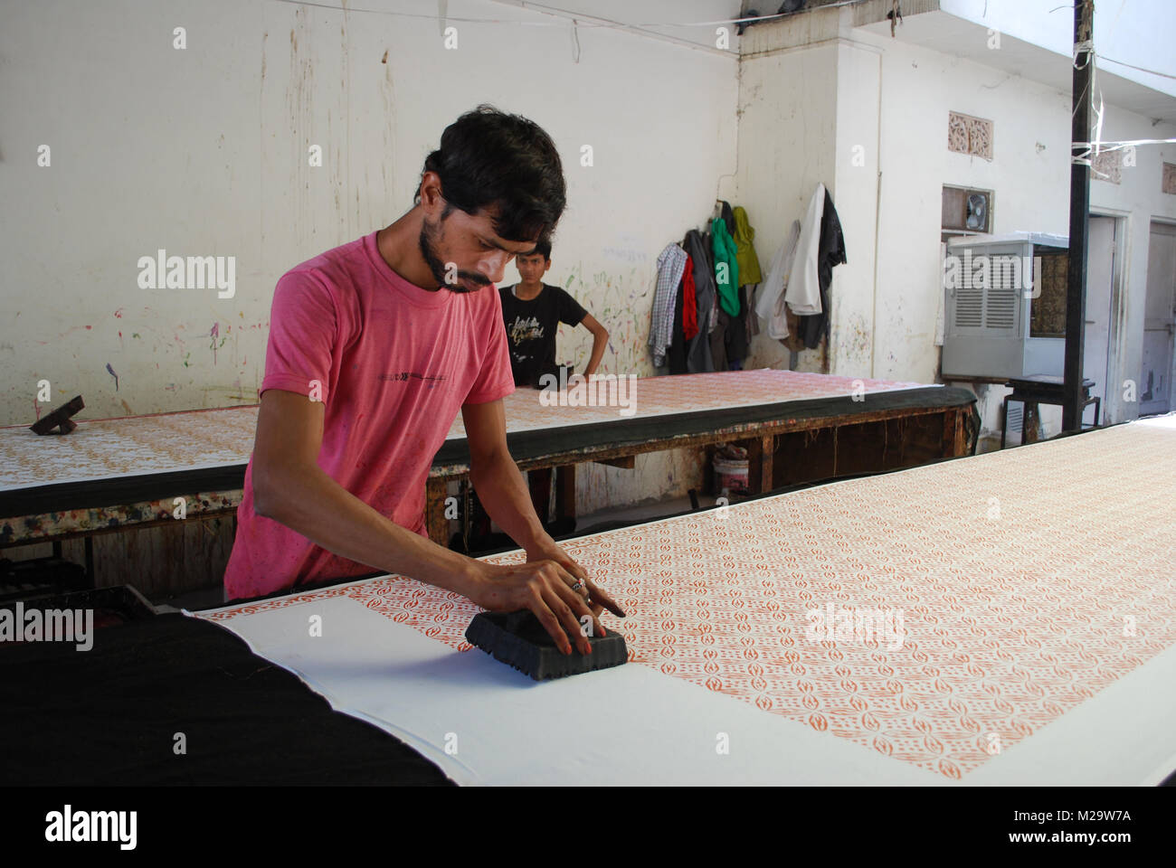 An indian craftsman block printing on fabric using traditional methods