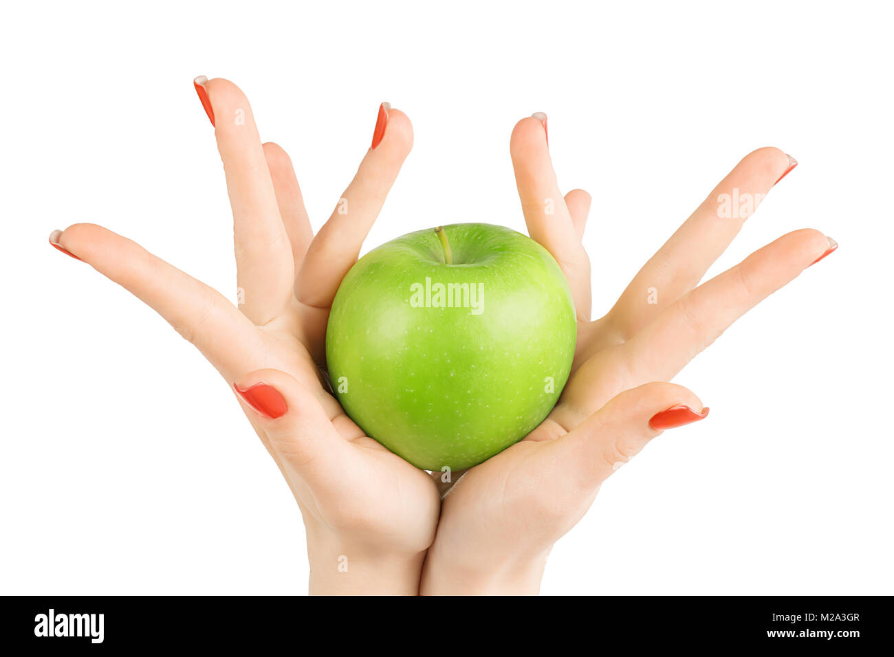 Woman hands with red nails polish and perfect skin holding green apple. Isolated on white, clipping path included Stock Photo