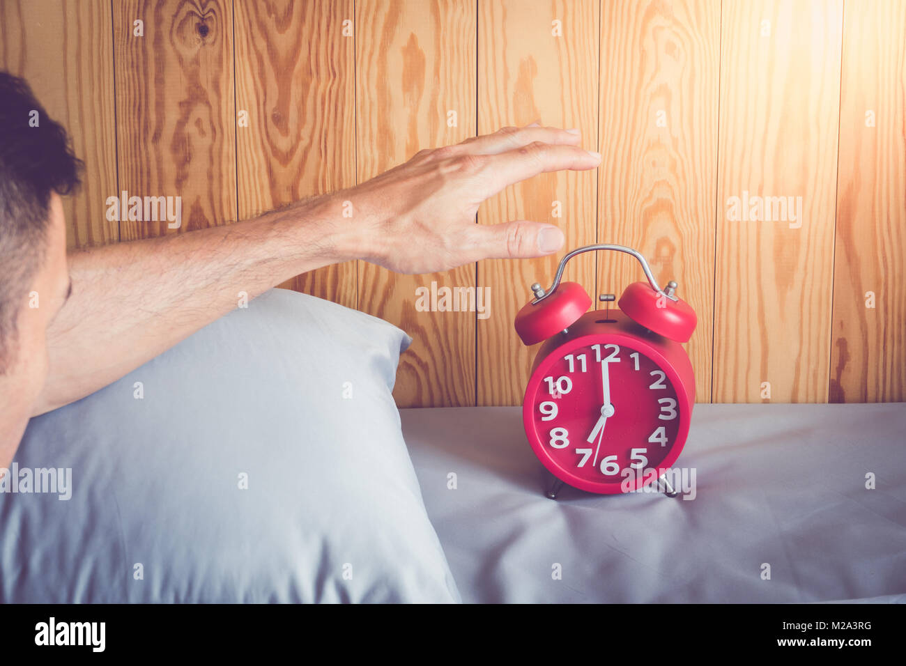 Hand turns off the alarm clock waking up at morning . soft skin tone