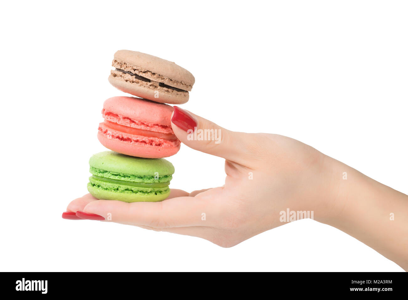Woman hand holding three colored macaroons. Isolated on white, clipping path included Stock Photo